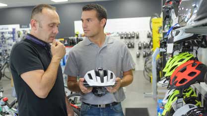 Mężczyzna wybiera kask rowerowy, jaki rozmiar ?